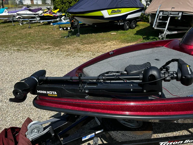 Slide: The Image of 1999 Triton 180 boat with Minn Kota Maxxum trolling motor, parked on gravel. - 5
