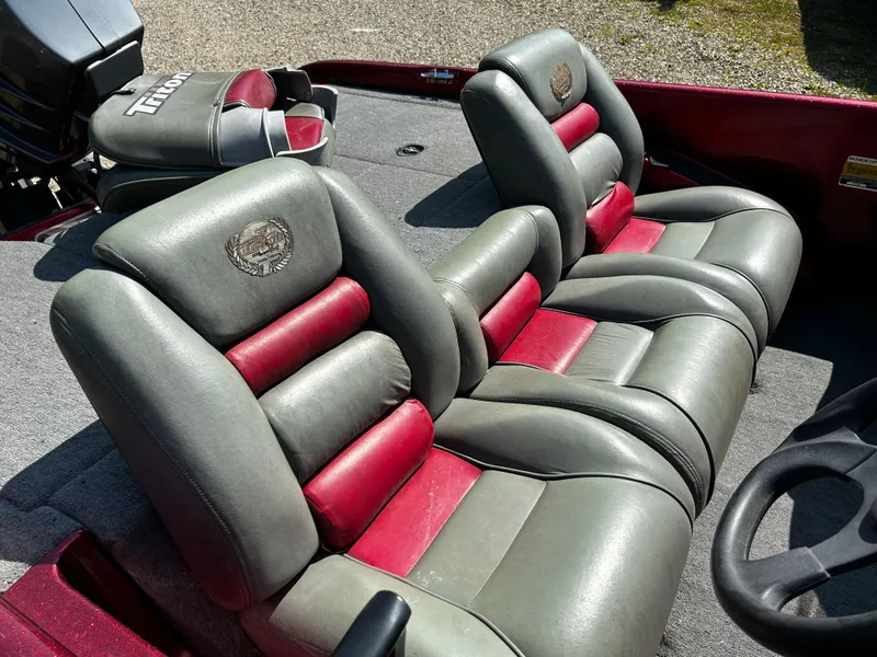 Slide: The Image of 1999 Triton 180 boat interior with gray and red cushioned seats. - 8