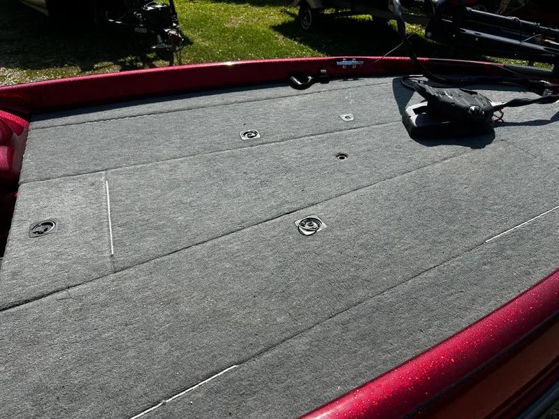 Slide: The Image of 1999 Triton 180 boat deck with gray carpet and red trim. - 9