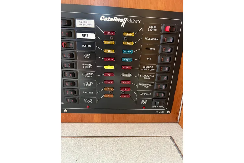Slide: The Image of Electrical control panel of a 2007 Catalina 309 yacht with labeled switches and fuses. - 16