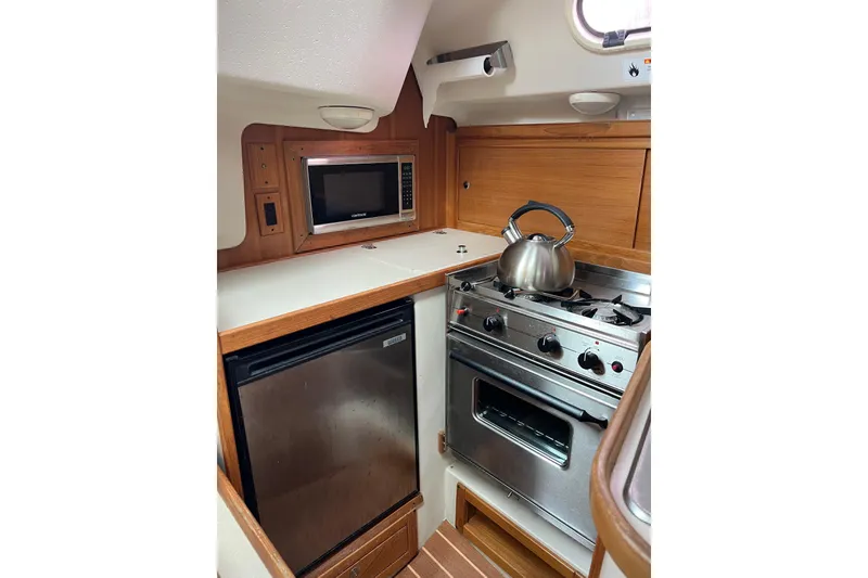 Slide: The Image of Compact kitchen in 2007 Catalina 309 yacht with stove, microwave, and fridge. - 18