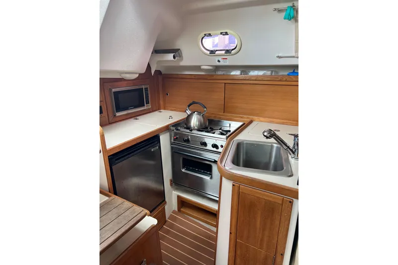 Slide: The Image of Compact galley kitchen in 2007 Catalina 309 sailboat with stove, sink, and microwave. - 19
