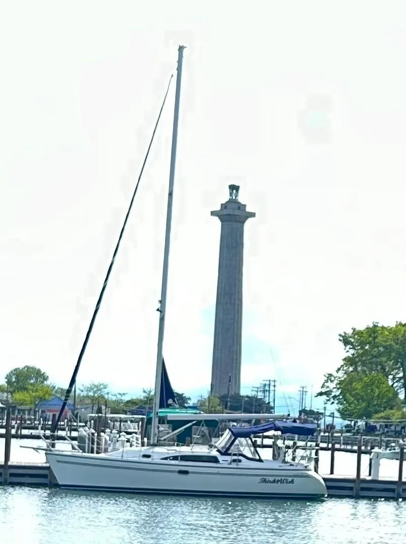 Slide: The Image of 2007 Catalina 309 sailboat docked near a tall monument in a marina. - 2