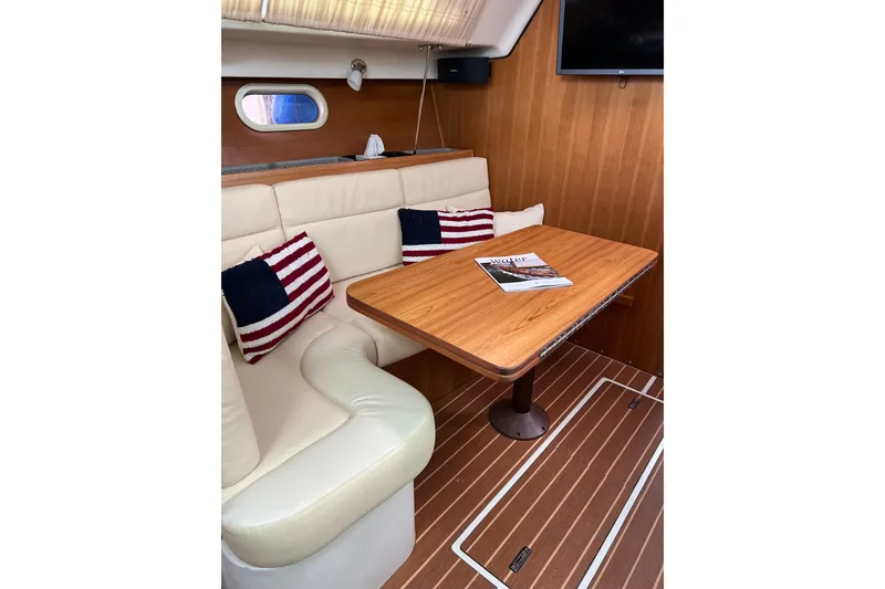 Slide: The Image of Interior of 2007 Catalina 309 sailboat with cozy seating and wooden table. - 22