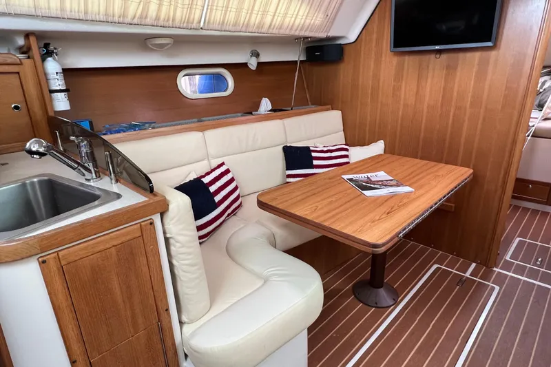 Slide: The Image of Luxurious 2007 Catalina 309 yacht interior with cozy seating, wooden table, and modern amenities. - 23