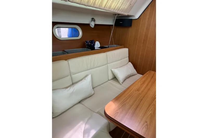 Slide: The Image of Interior of 2007 Catalina 309 sailboat with white cushions and wooden table. - 26