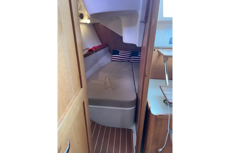 Slide: The Image of Interior cabin of 2007 Catalina 309 sailboat with cozy bed and wooden accents. - 27