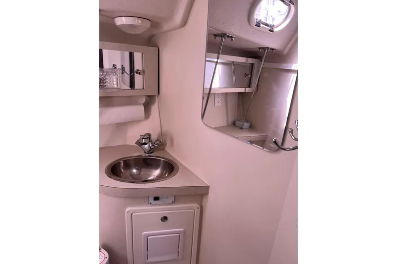 Slide: The Image of Catalina 309 (2007) yacht bathroom with sink, mirror, and storage shelves. - 30