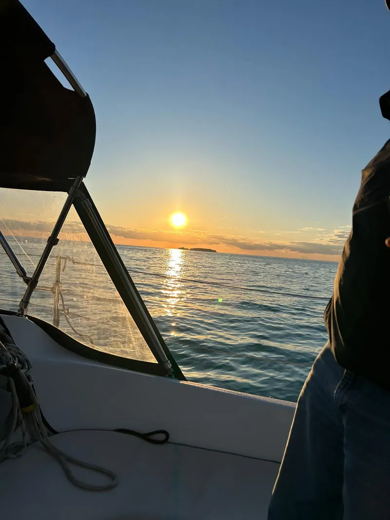 Slide: The Image of Sailing on a 2007 Catalina 309 at sunset, with a serene ocean view. - 9