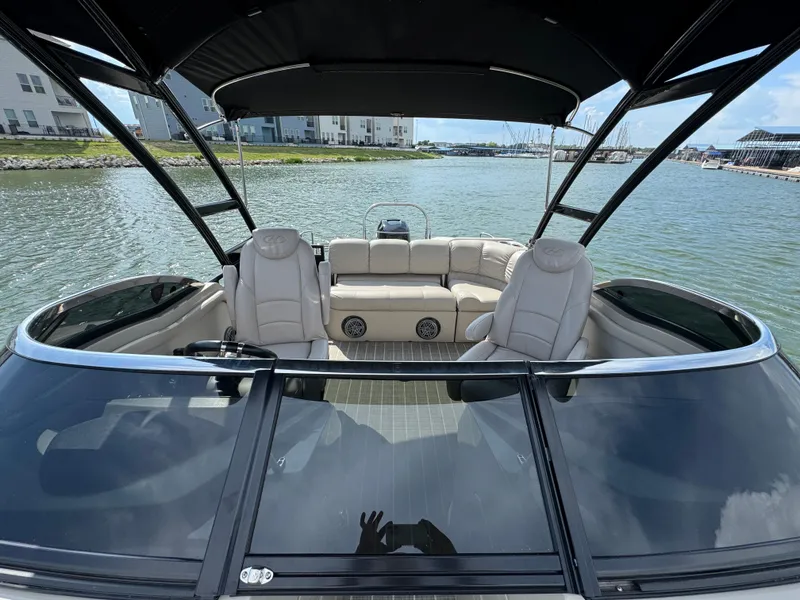 Slide: The Image of 2016 Harris Solstice DC 250 boat interior with seating, on a calm waterfront. - 10