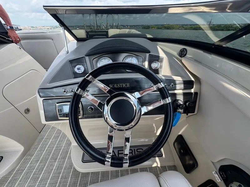 Slide: The Image of Steering wheel and dashboard of 2016 Harris Solstice DC 250 boat on water. - 13