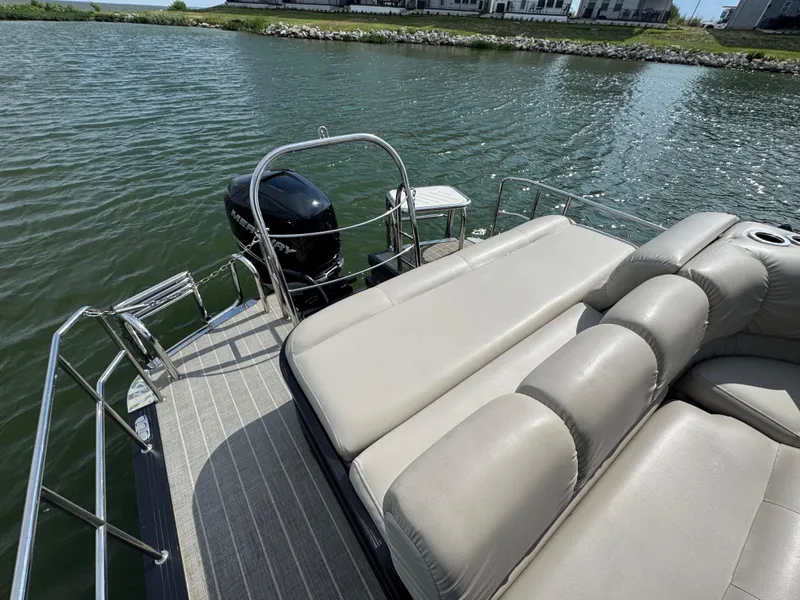 Slide: The Image of 2016 Harris Solstice DC 250 boat with plush seating on a calm lake. - 17