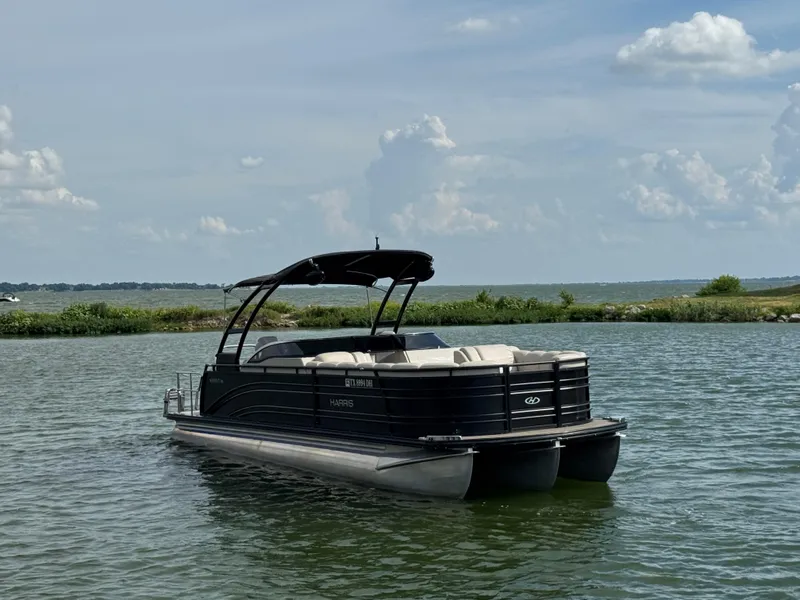 Slide: The Image of 2016 Harris Solstice DC 250 pontoon boat on a calm lake under a clear sky. - 4
