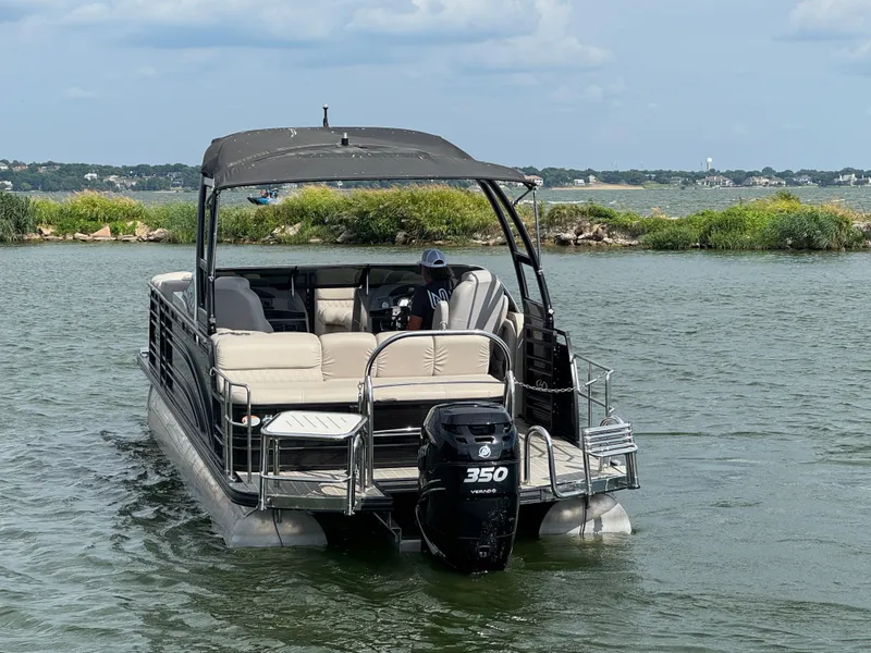 Slide: The Image of 2016 Harris Solstice DC 250 pontoon boat on a lake with lush greenery. - 5