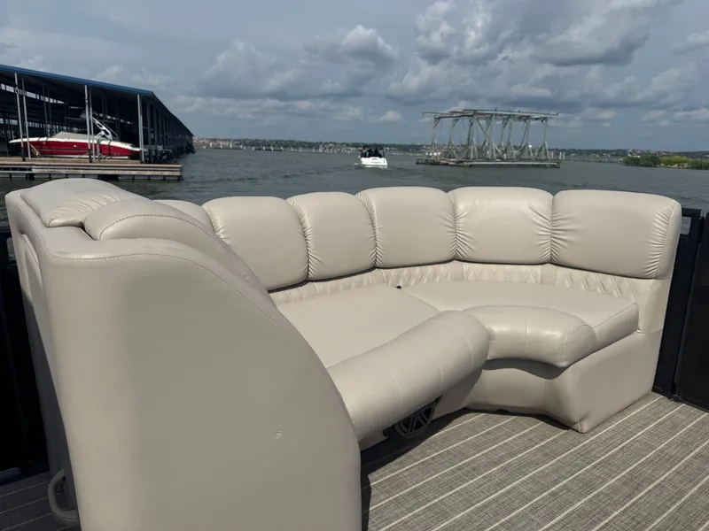 Slide: The Image of Luxurious seating on a 2016 Harris Solstice DC 250 boat, docked by a lake. - 6