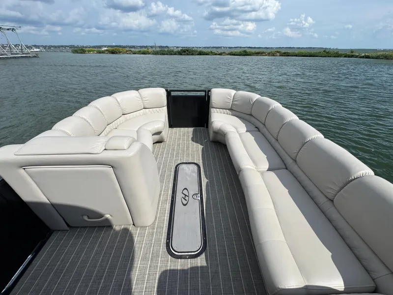 Slide: The Image of 2016 Harris Solstice DC 250 pontoon boat with spacious seating on a calm lake. - 8