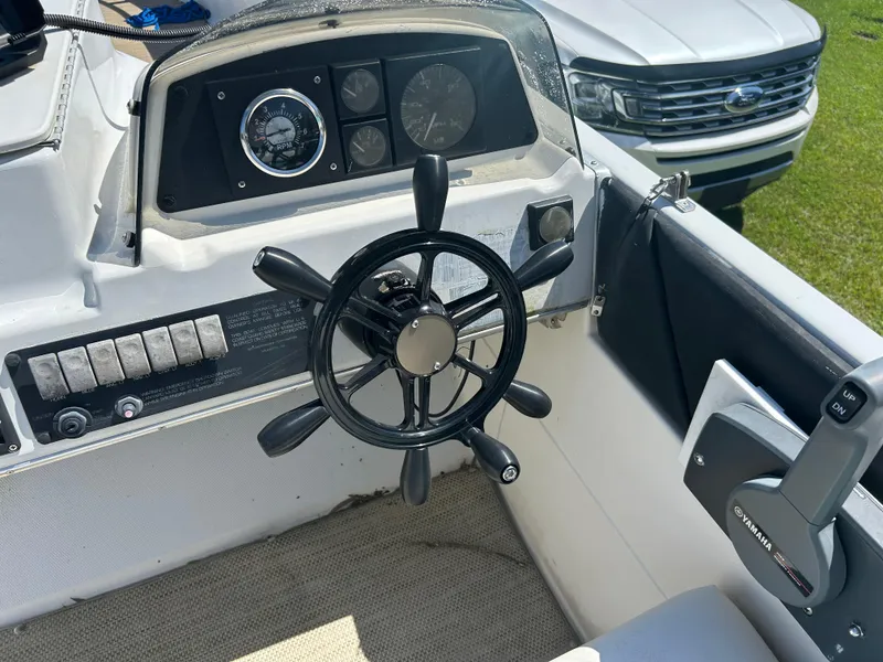 Slide: The Image of 1998 Bayliner Rendevous 26 boat dashboard with steering wheel and Yamaha controls. - 10