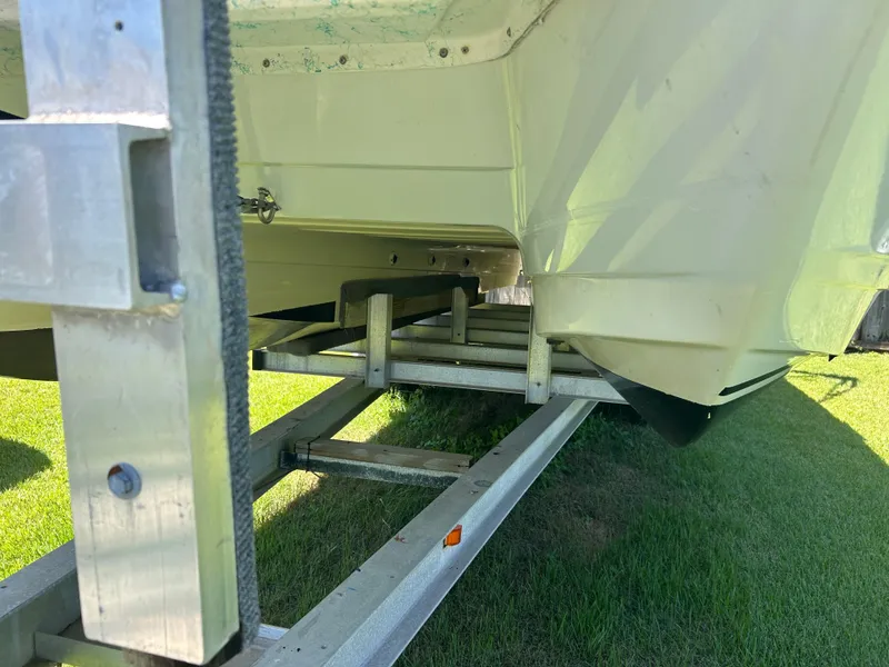 Slide: The Image of 1998 Bayliner Rendevous 26 boat on trailer, showing hull and trailer details. - 16