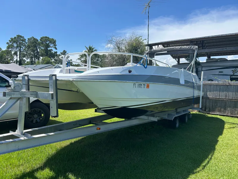 Slide: The Image of 1998 Bayliner Rendevous 26 boat on trailer, parked outdoors under clear sky. - 2