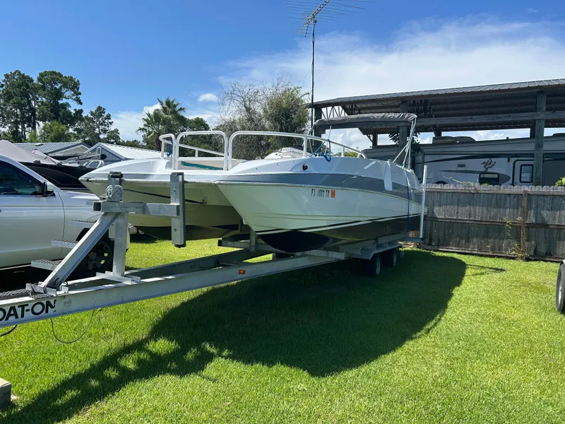Slide: The Image of 1998 Bayliner Rendevous 26 boat on trailer, parked on grass under clear sky. - 3