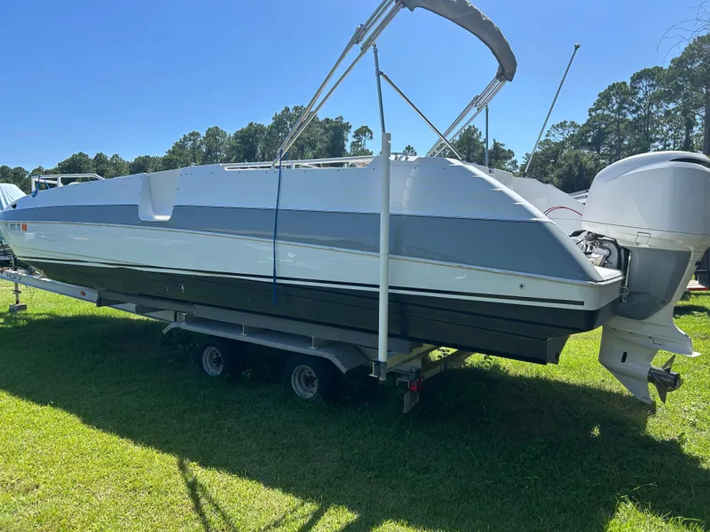 Slide: The Image of 1998 Bayliner Rendevous 26 boat on trailer, parked on grass under clear blue sky. - 4