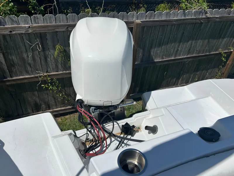 Slide: The Image of 1998 Bayliner Rendevous 26 boat engine, white exterior, near wooden fence. - 6