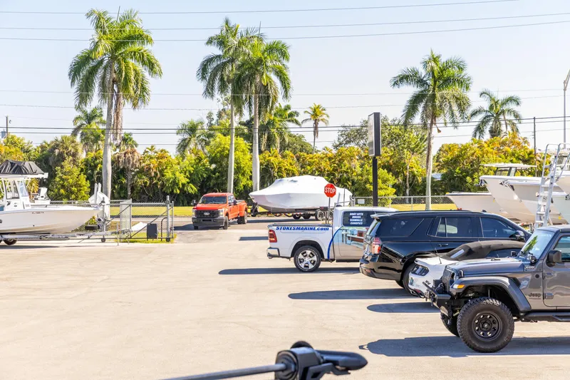 Slide: The Image of Parking lot with Crevalle 26 HCO boat, surrounded by palm trees and vehicles, 2026 model. - 14