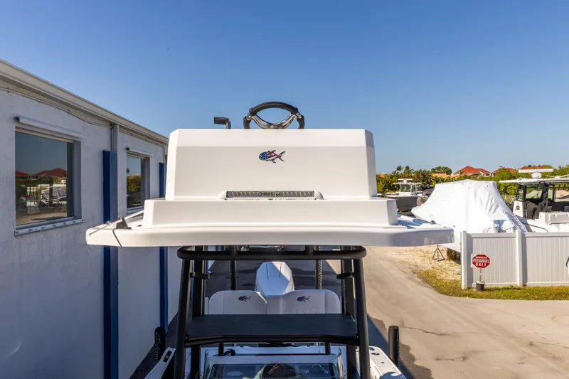 Slide: The Image of 2026 Crevalle 26 HCO boat with elevated helm station, parked outdoors. - 18