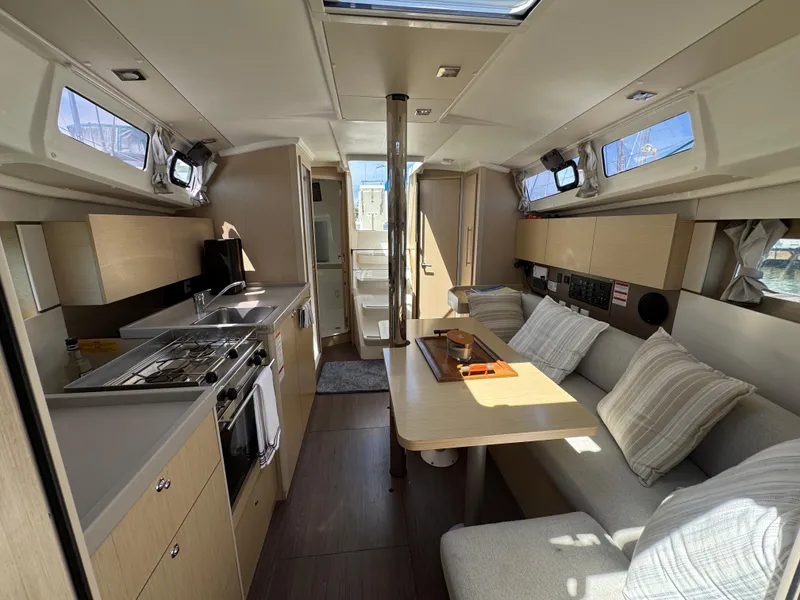 Slide: The Image of Interior of 2021 Beneteau Oceanis 35.1 yacht, featuring modern kitchen and cozy seating area. - 16