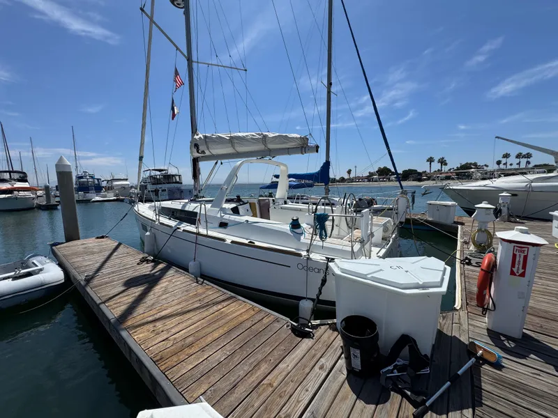 Slide: The Image of 2021 Beneteau Oceanis 35.1 sailboat docked at marina under clear blue sky. - 3