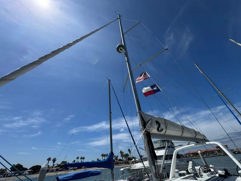 Slide: The Image of Sailboat Beneteau Oceanis 35.1, 2021 model, with flags, docked under clear blue sky. - 6