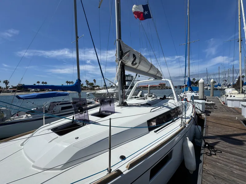 Slide: The Image of 2021 Beneteau Oceanis 35.1 sailboat docked at marina under clear blue sky. - 7