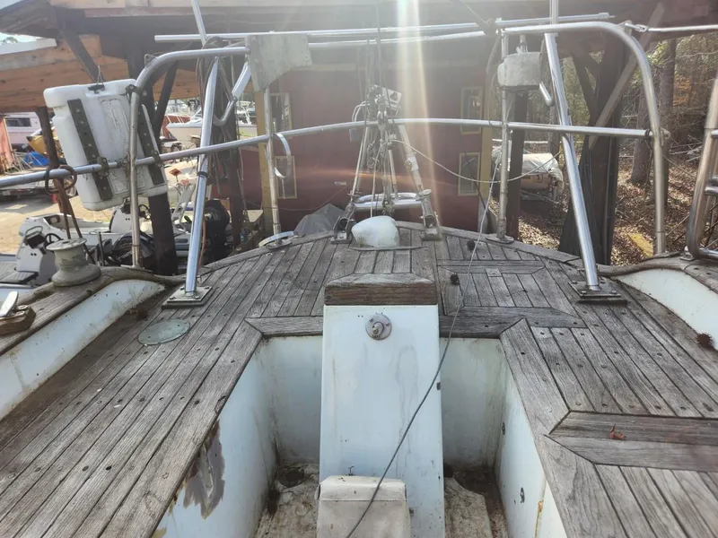 Slide: The Image of 1976 Tayana 37 sailboat deck with wooden finish and metal railings. - 18