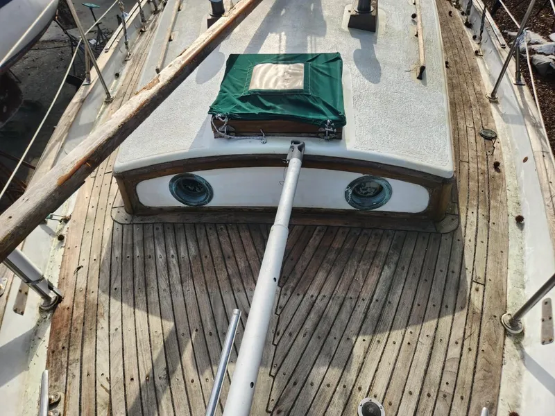 Slide: The Image of 1976 Tayana 37 sailboat deck with wooden finish and green hatch cover. - 22