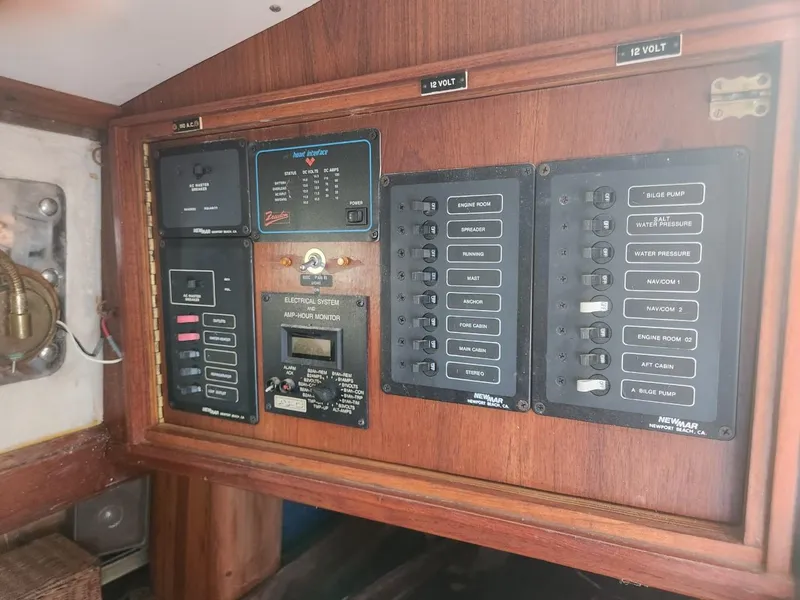 Slide: The Image of Electrical control panel on a 1976 Tayana 37 sailboat, featuring various switches and meters. - 23