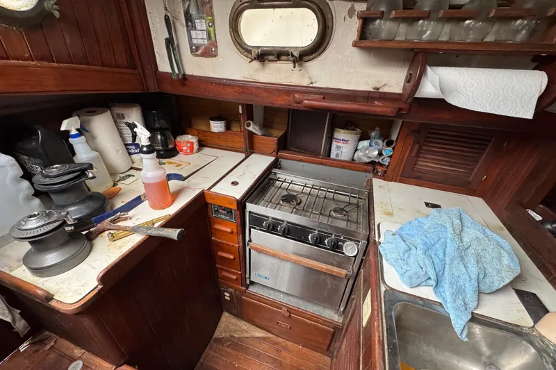 Slide: The Image of 1976 Tayana 37 yacht galley with stove, sink, and wooden cabinetry. - 41
