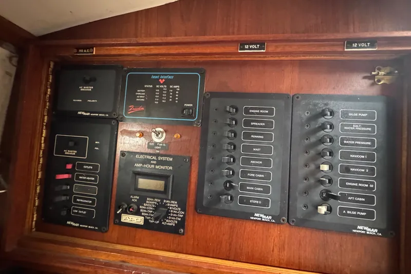 Slide: The Image of Electrical control panel on a 1976 Tayana 37 sailboat, featuring various switches and monitors. - 42