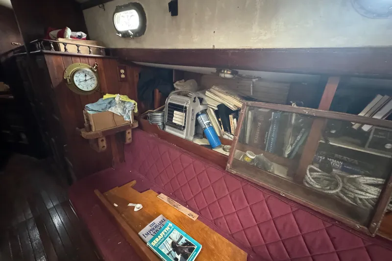 Slide: The Image of Interior of a 1976 Tayana 37 sailboat with books, clock, and nautical decor. - 43