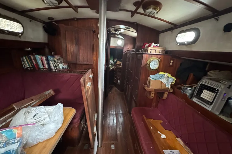 Slide: The Image of Interior of a 1976 Tayana 37 sailboat with wooden furnishings and cozy seating. - 46