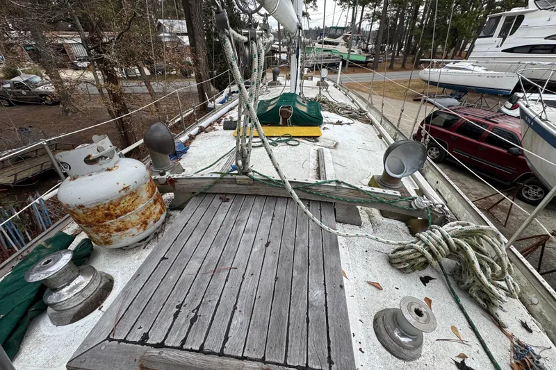 Slide: The Image of 1976 Tayana 37 sailboat deck with ropes and rusted propane tank. - 55