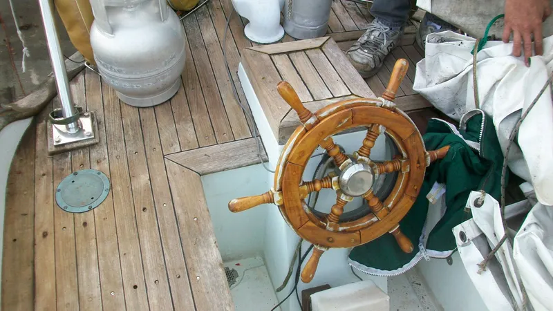 Slide: The Image of Wooden steering wheel on 1976 Tayana 37 sailboat deck with nautical equipment. - 6