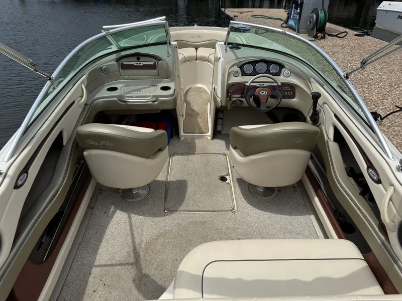 Slide: The Image of 2004 Sea Ray 220 Select boat interior with beige seating and dashboard controls. - 16