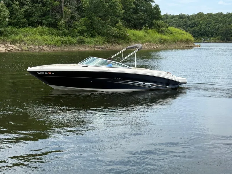 Slide: The Image of 2004 Sea Ray 220 Select boat with beige seating, docked by the water. - 4