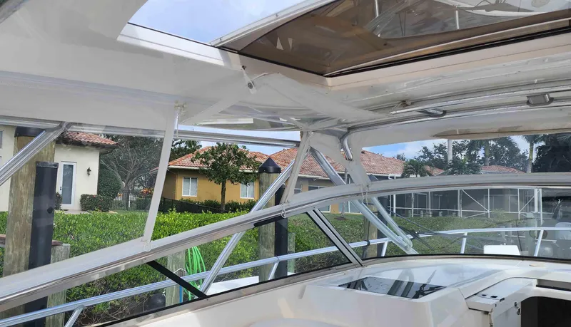 Slide: The Image of 2008 Intrepid 430 Sport Yacht interior with open roof and residential background. - 11
