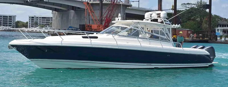 Slide: The Image of 2008 Intrepid 430 Sport Yacht cruising in turquoise waters near a bridge. - 2