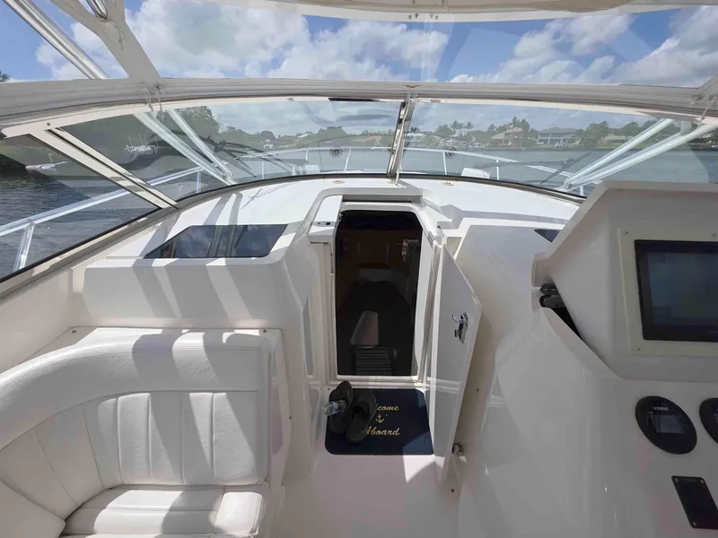 Slide: The Image of 2008 Intrepid 430 Sport Yacht cockpit with open cabin door, featuring sleek design and modern controls. - 25