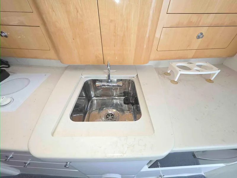 Slide: The Image of 2008 Intrepid 430 Sport Yacht kitchen sink with wooden cabinets and countertop. - 32