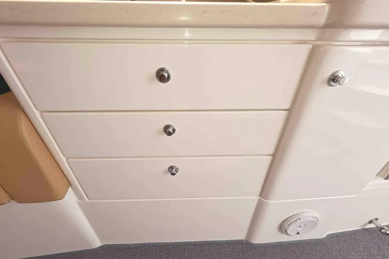 Slide: The Image of 2008 Intrepid 430 Sport Yacht interior with white storage drawers and beige seating. - 35