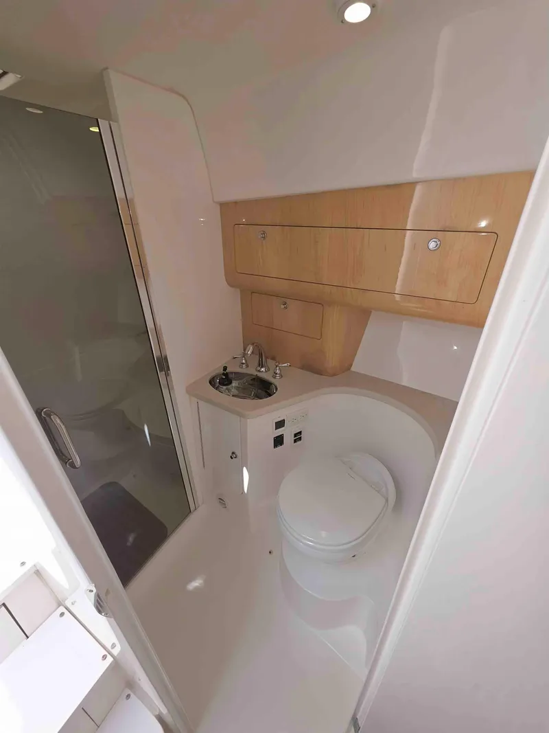 Slide: The Image of 2008 Intrepid 430 Sport Yacht bathroom with compact design, featuring sink, toilet, and storage cabinets. - 46