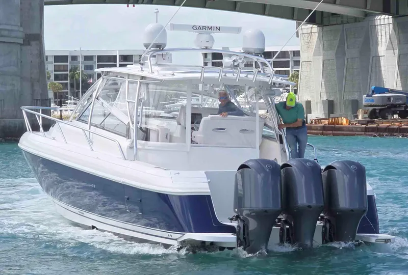 Slide: The Image of 2008 Intrepid 430 Sport Yacht cruising under a bridge with triple outboard engines. - 56